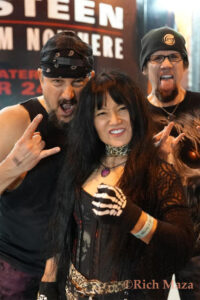 PowerTribe band posing outside with horns up and tongues out on the Sunset Strip at the Whisky a Go Go